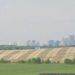 Alberta farm scene and downtown Calgary in distance